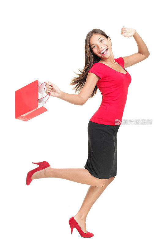 购物的女人在快乐地跑着拿着包