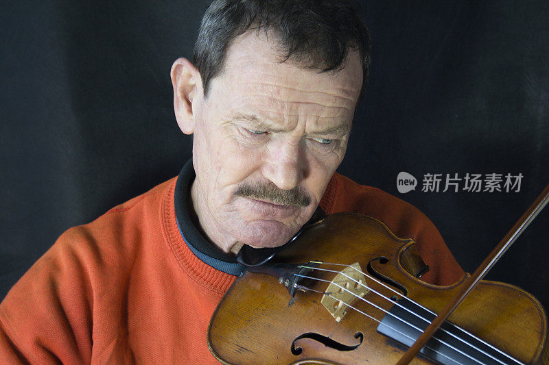 男人玩小提琴。