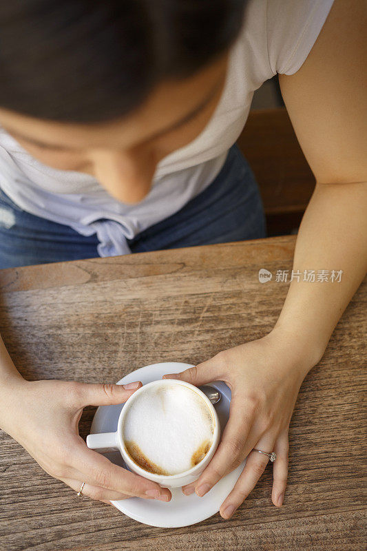 在咖啡馆喝咖啡的年轻女子