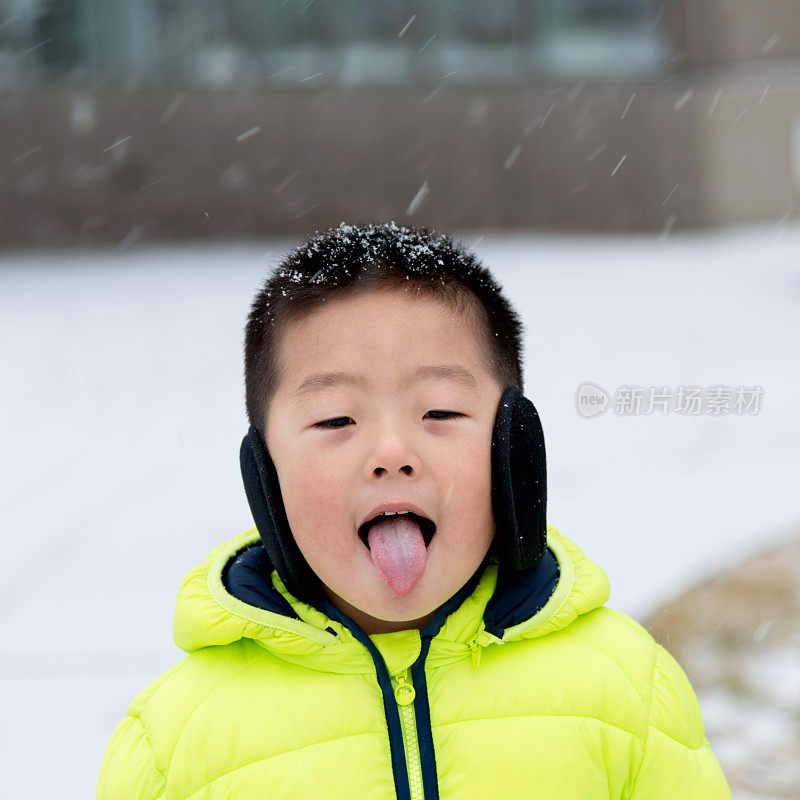 一个亚洲男孩在雪地里玩