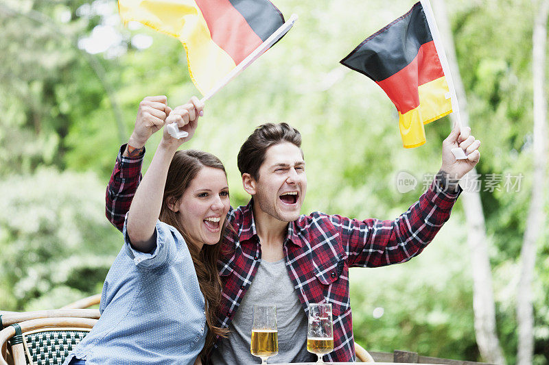 德国夫妇庆祝并挥舞国旗，德国国旗