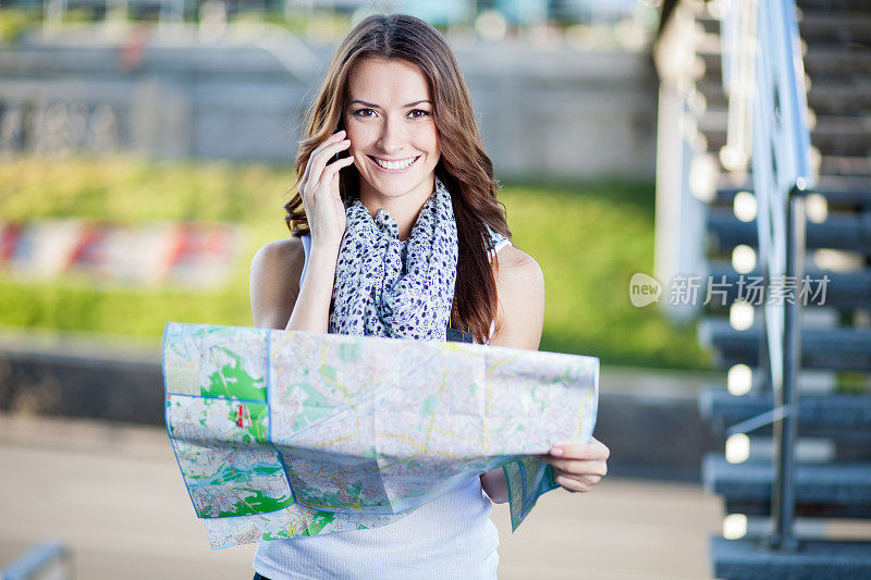 年轻的女游客拿着纸地图在户外