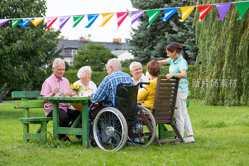 一群老人围坐在花坛桌前庆祝