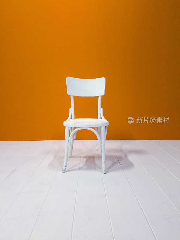白色的木椅和橘色的墙