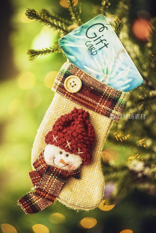 圣诞礼物卡在圣诞袜挂在树上