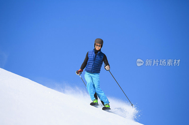 年轻人在阳光明媚的滑雪场滑雪