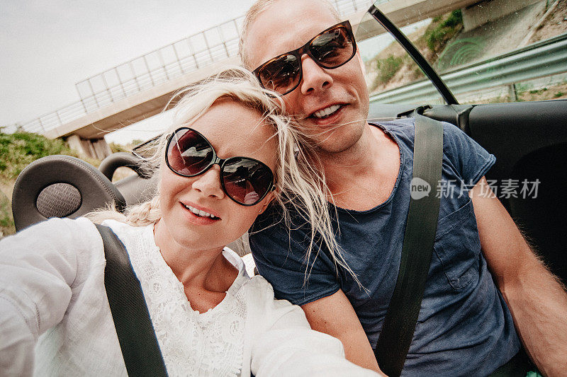 夫妇在公路旅行的cabriolet汽车通过欧洲