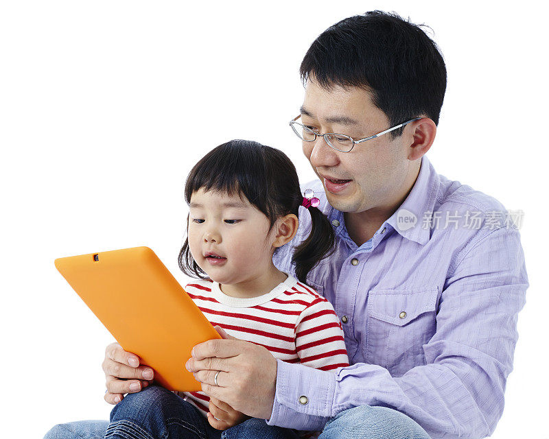 父亲和女儿在用数码平板电脑