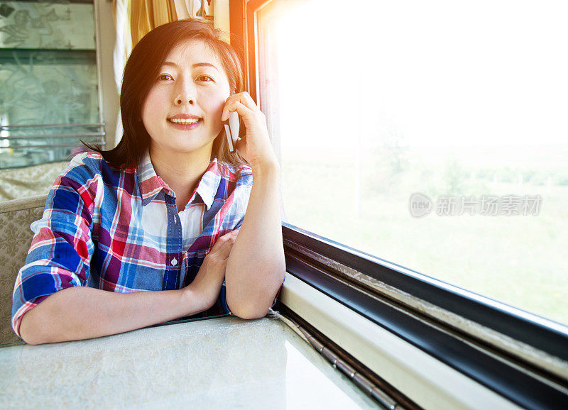 年轻女子在火车上用智能手机