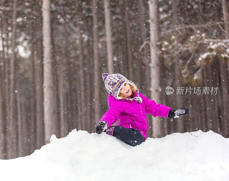 冬天，小女孩在雪堆上玩耍