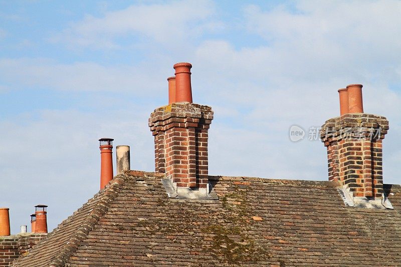 维多利亚时代的陶土烟囱和瓦片屋顶上的砖烟囱