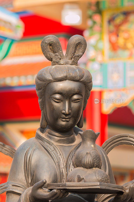 中国女孩雕像举着一壶茶