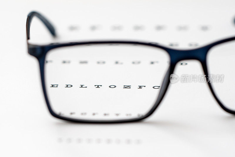 阅读黑色眼镜和视力表近景，浅景深