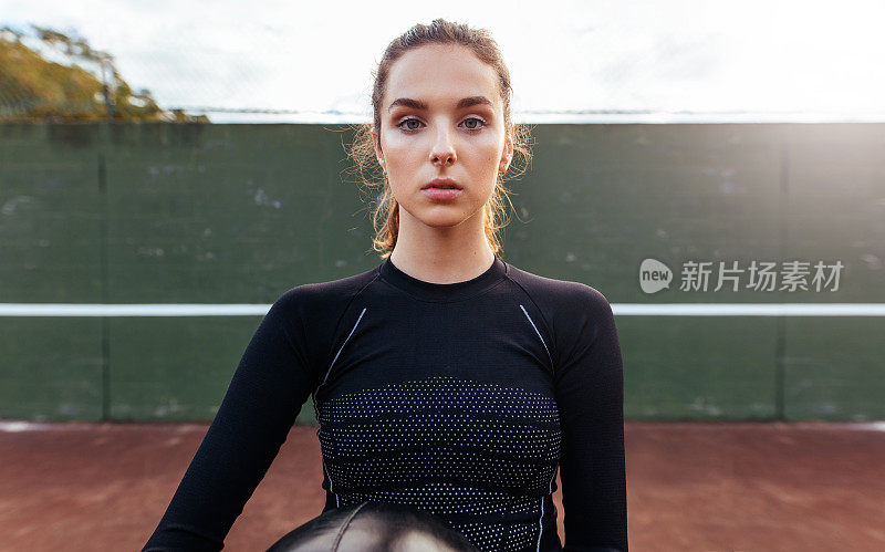 年轻女运动员在网球场上的肖像