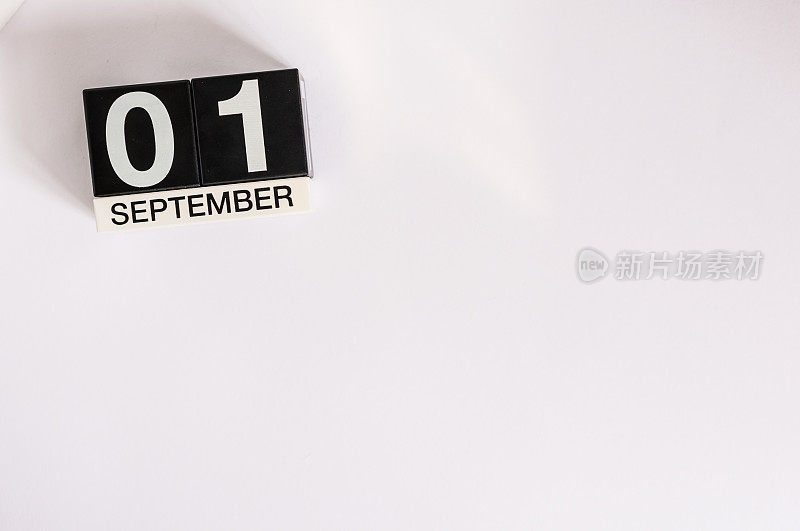 9月1日。月的第一天，木制的黑色日历在白色的背景上。秋天的时间。文本的空白。回到学校