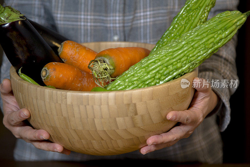 手捧着木碗里的蔬菜