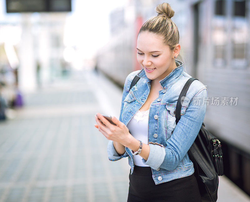 美丽的年轻女子在现实生活中使用智能手机