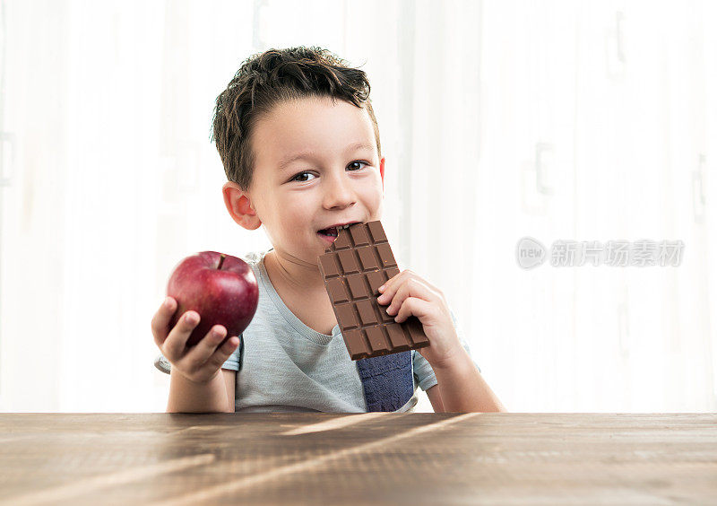 孩子正在巧克力和苹果之间做选择。