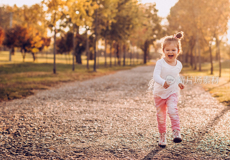 可爱的小女孩在公园里跑步