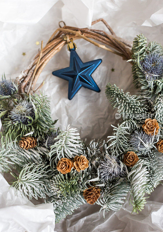 室内设计、种植、度假理念。手工装饰的圣诞庆祝，花环由天然材料，点缀深蓝色的玩具树的形式的星星