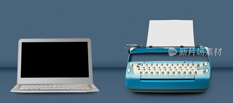 旧的电动打字机和笔记本电脑在蓝色的桌子背景