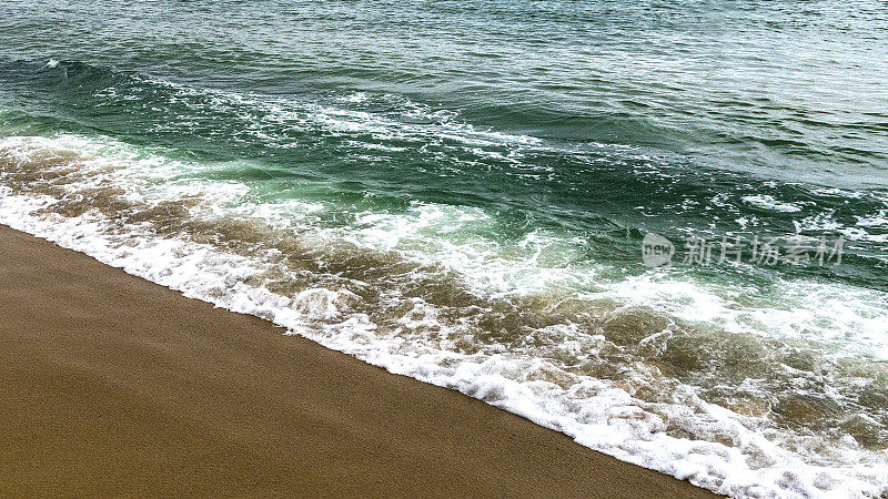 沙滩上翠绿的海浪(照片格式16:9)