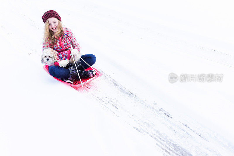 少女拉着小狗雪橇