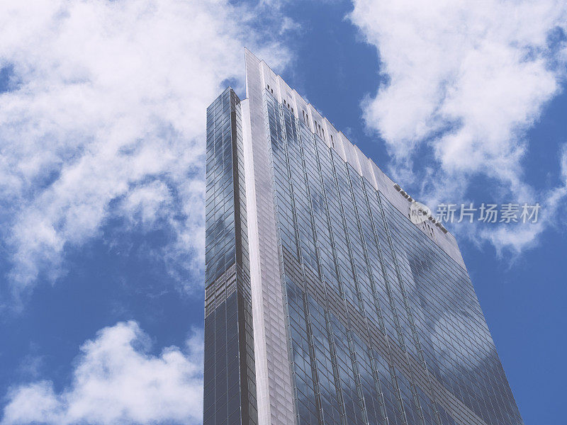 蓝天白云映在玻璃建筑上
