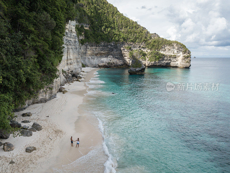 鸟瞰热带海滩上的年轻情侣享受度假和大自然，人们旅游探险的理念