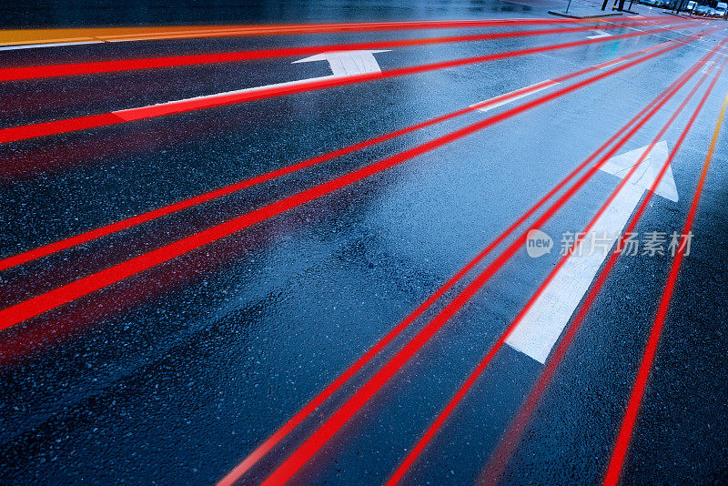 雨淋湿了柏油路，箭矢和运动模糊了汽车