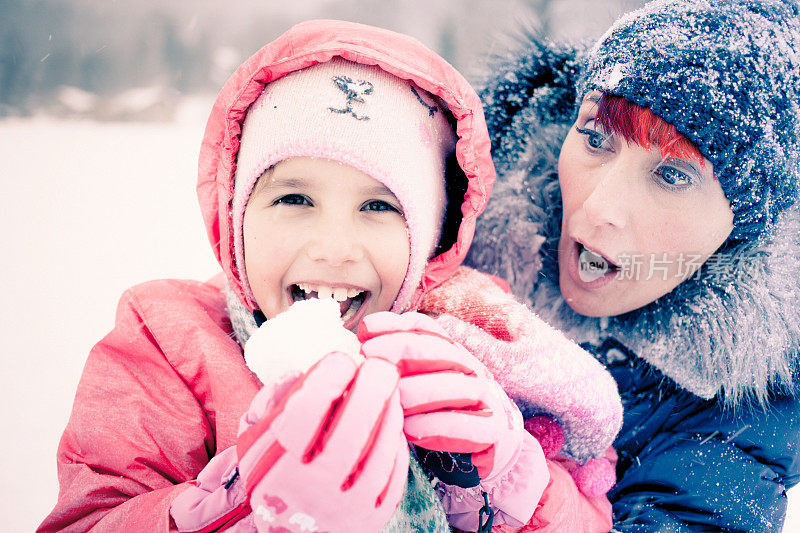 当女儿吃雪时，焦虑的母亲