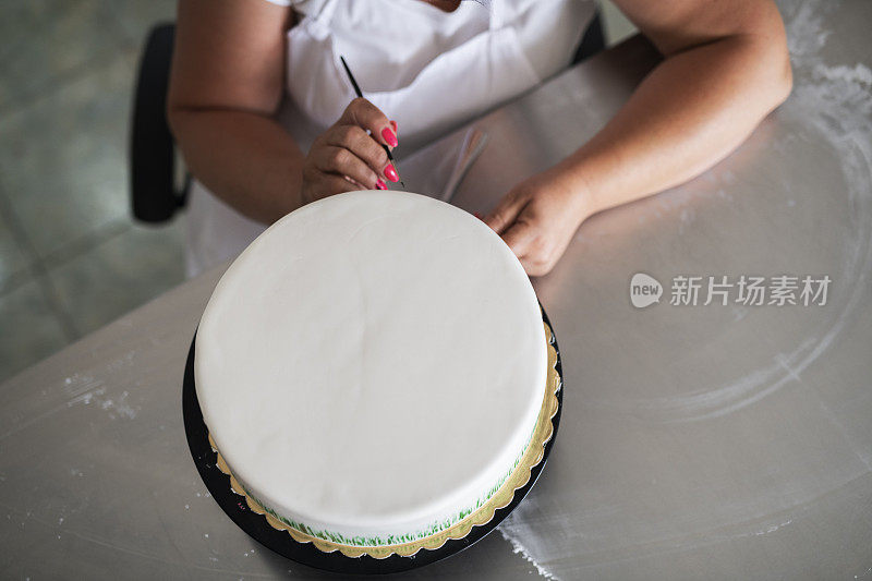 女性糖果师双手制作蛋糕。