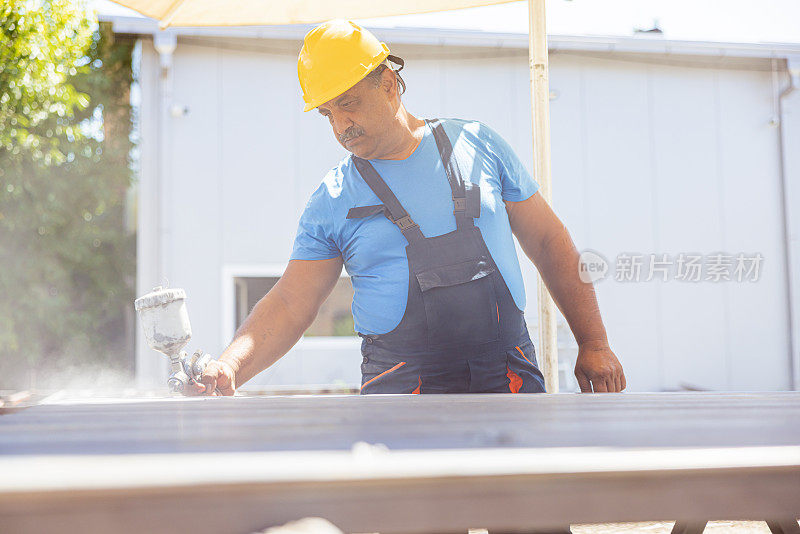 印度建筑工人在现场涂金属材料。