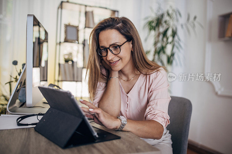 在家庭办公室的电脑前工作的女人