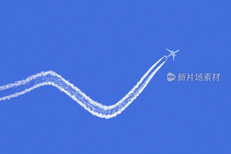 一架凝结着水汽的商用客机在蓝天上留下了痕迹——这就是空中旅行的起伏