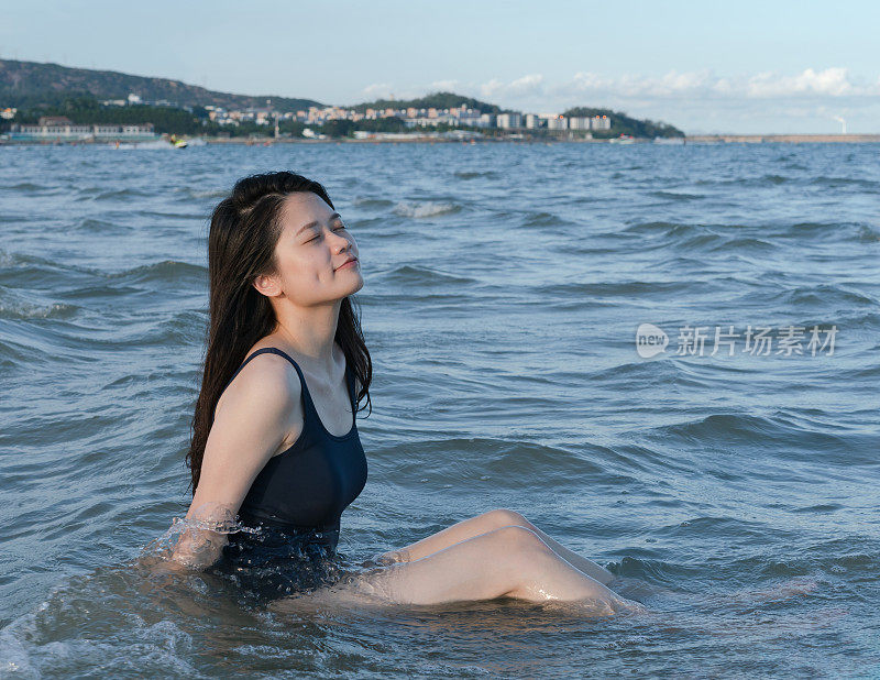 年轻的女人坐在海里