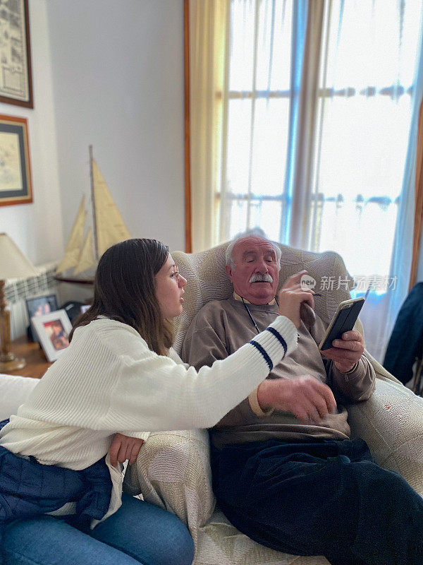 年轻的女孩教他的祖父如何使用手机