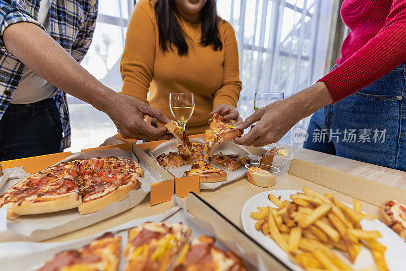 一群吃意大利披萨的员工在午餐或晚餐店手工挑选披萨。美味的海鲜肉汁酱。传统的意大利快餐在木桌上喝葡萄酒。