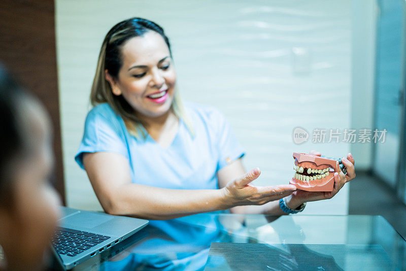 牙医在办公室向病人解释假牙