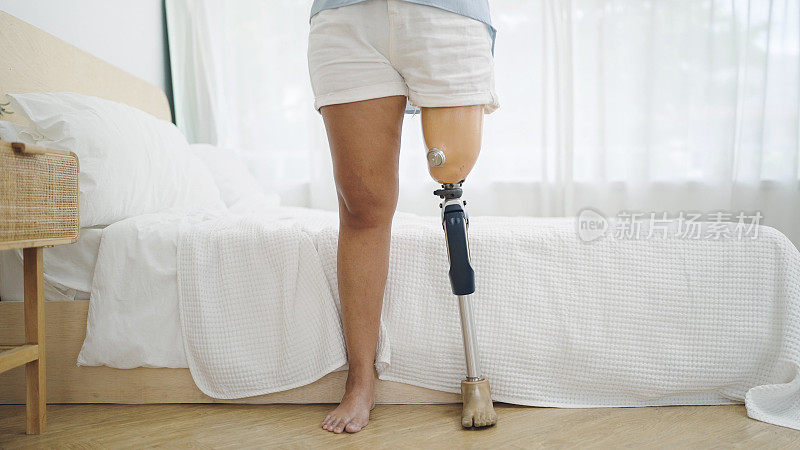 近距离截肢者站在卧室的假肢设备。残疾人生活中的困难，身体残疾，假肢设备，截肢者概念