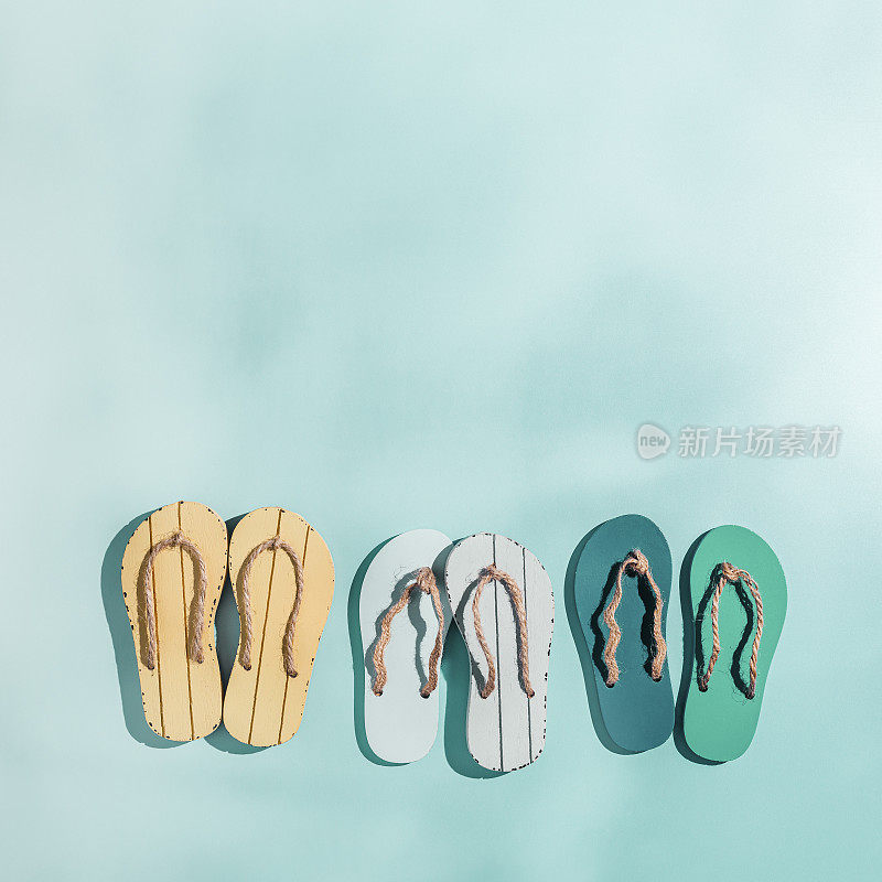 女式夏季鞋凉鞋，极简布局与硬阴影，蓝绿色渐变背景上的蓝绿黄色人字拖。审美潮流夏季时尚概念，生活方式写真，文案空间