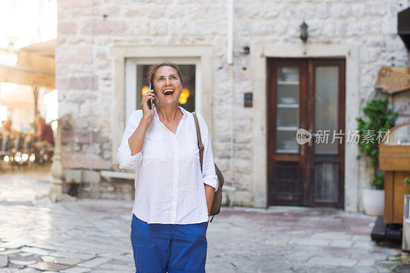 快乐的成熟女人边走边打电话