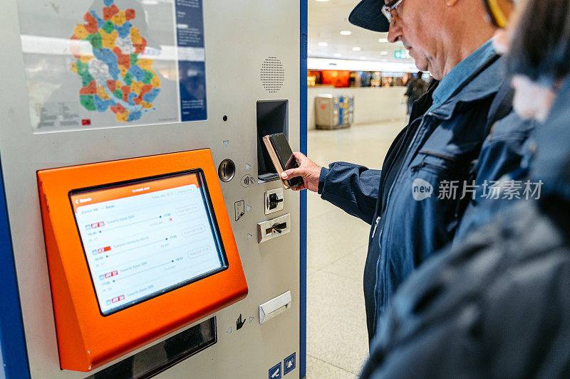 老人在苏黎世火车站用智能手机买火车票