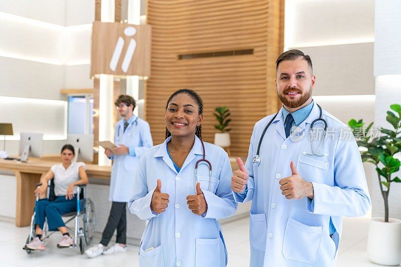 多元化的医疗团队:黑人女医生和白人男同事竖起大拇指