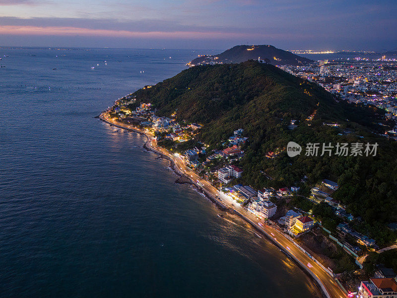 从上面俯瞰云头海岸全景，海浪、海岸线、街道、椰子树、越南Nho山后面的基督国王雕像