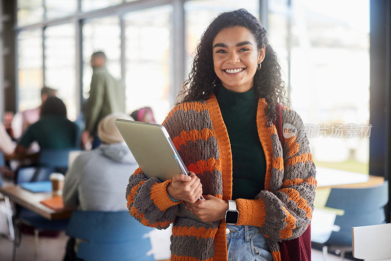 微笑的年轻女学生站在大学自助餐厅拿着笔记本电脑