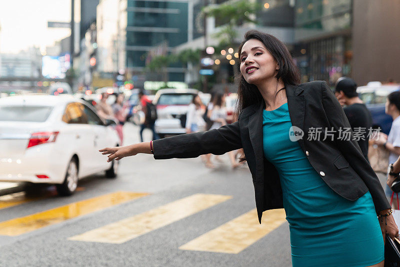 吉隆坡街头，一名女子挥手示意拦下一辆出租车