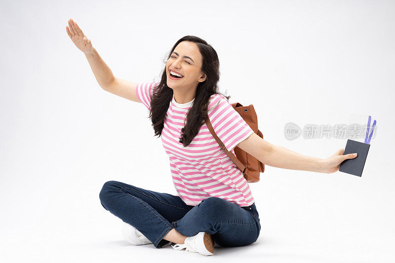 漂亮女孩的全尺寸照片坐在地板上的现代服装孤立的白色背景股票照片