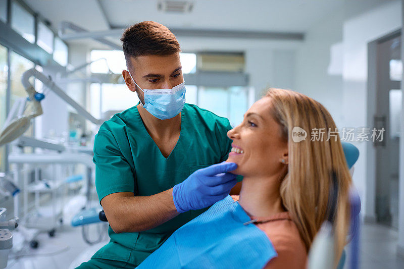 牙医在牙科诊所检查女病人的牙齿。