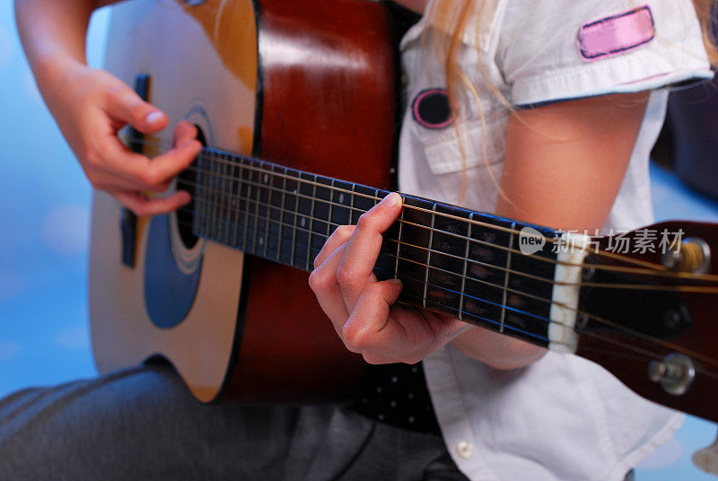 小女孩在舞台上弹原声吉他